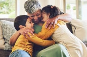 Grandma giving two grandchildren a great big hug